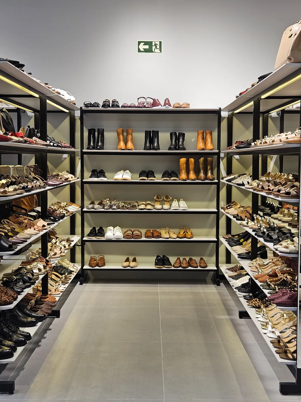 Footwear displayed along a shoe store aisle