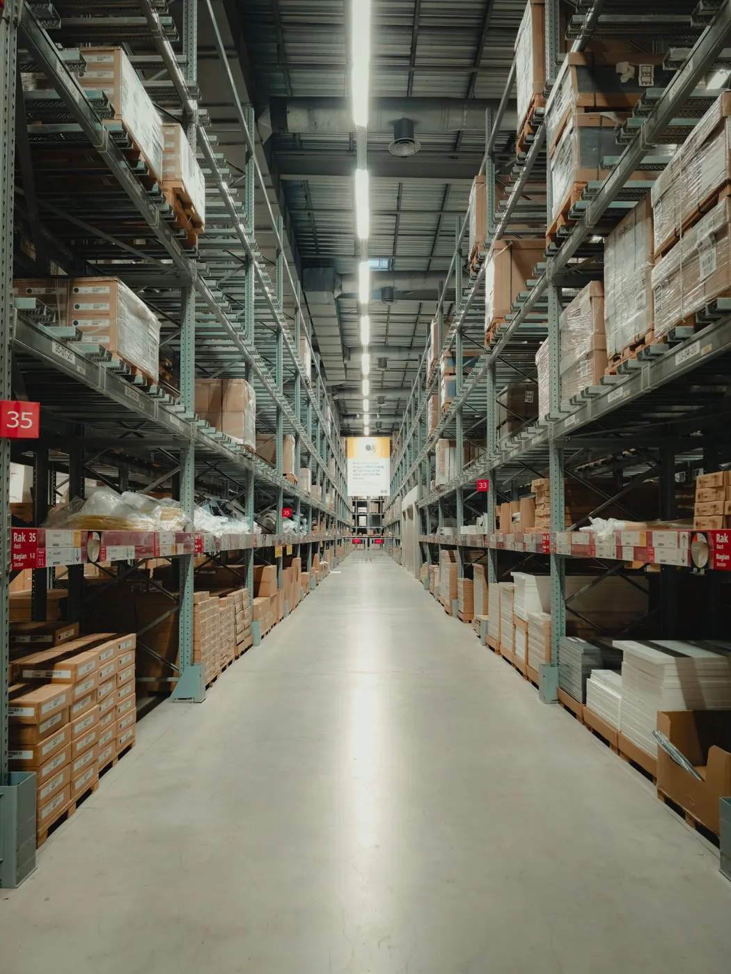 Stocked shelves and pallets along a warehouse aisle
