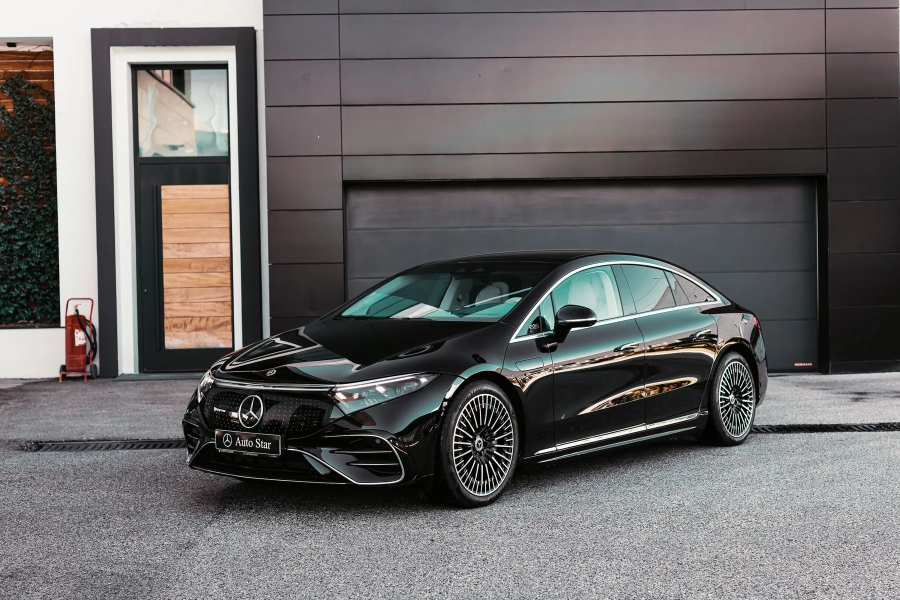 A black luxury sedan outside a modern building